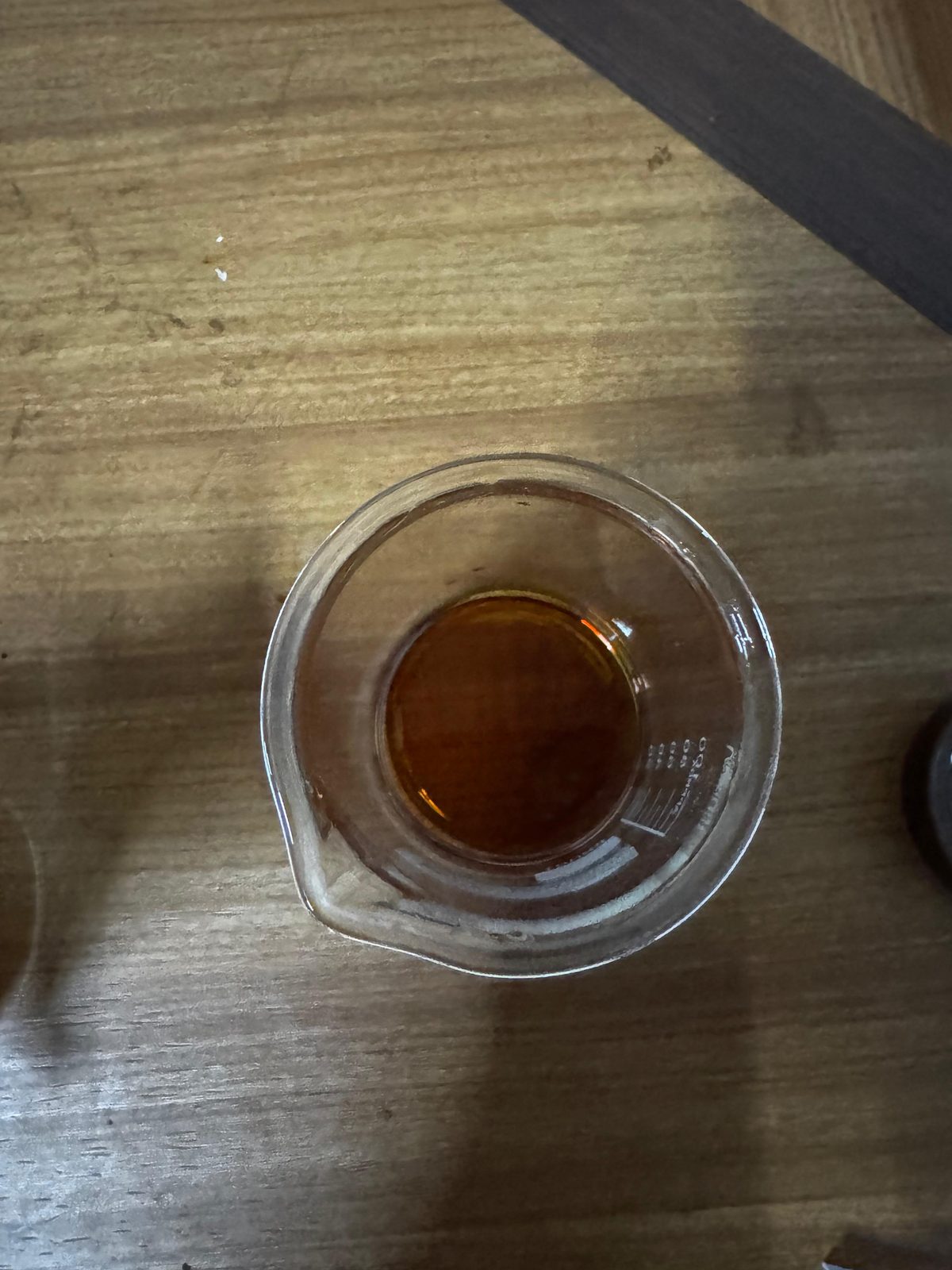 Close-up of amber patchouli oil in a glass beaker